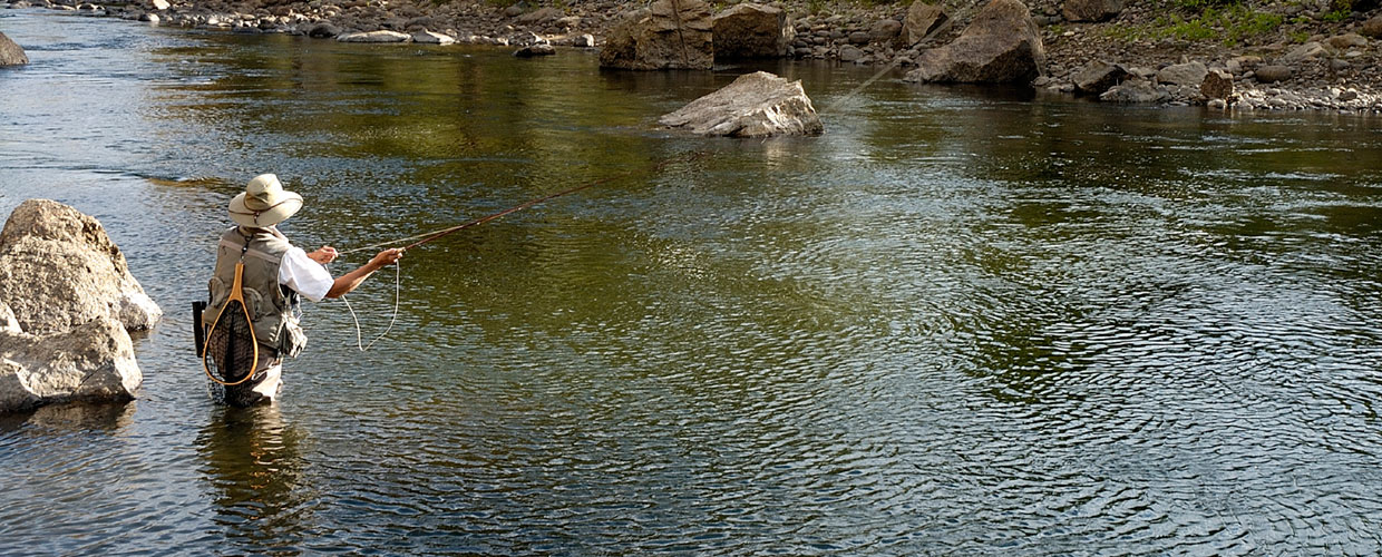 fly fisherman casting in river